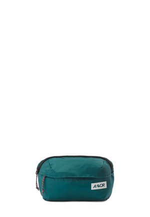 Türkisfarbene rechteckige Bauchtasche mit zwei Reißverschluss-Schiebern, schwarzem Besatz und weißem AËVOR-Logo auf der Vorderseite, vor weißem Hintergrund isoliert.