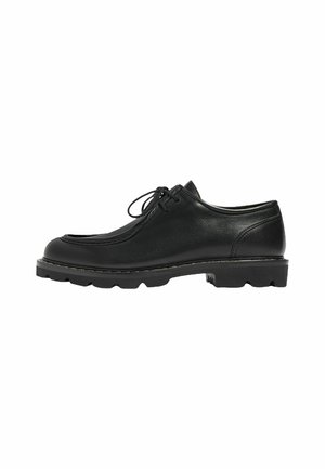 Zapato de cuero negro con punta redondeada, costuras visibles y diseño de cordones. Suela plana y texturizada que mejora la tracción y la estabilidad.