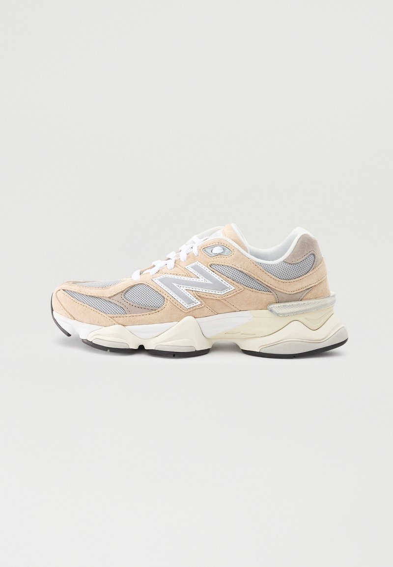 Beige and gray athletic shoe featuring mesh and suede materials, a layered design, white accents, and a cushioned sole.