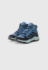 Blue hiking shoes with a mesh and synthetic upper, black rubber soles, prominent lacing system, and three black stripes on the sides.