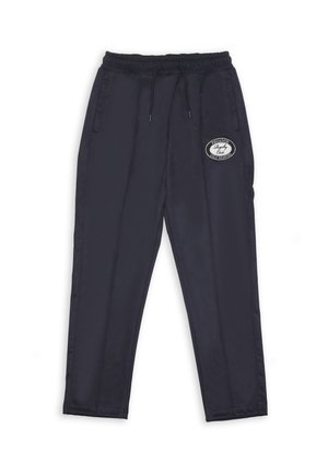 Pantalones de chándal negros con cintura elástica, cordón, bolsillos laterales y un parche circular con logo blanco en el muslo derecho.