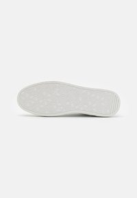 Suela de zapato en goma blanca con un patrón hexagonal texturizado y geométrico. Diseño plano con un borde suave y sin logotipos visibles.