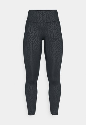 Leggings negros con un sutil patrón de estampado animal, de cintura alta y tejido elástico, diseñados para la comodidad y la flexibilidad en el movimiento.