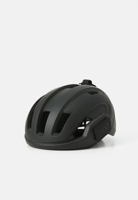 Casque de vélo noir avec une finition mate lisse, plusieurs fentes de ventilation et une sangle d'ajustement sécurisée arborant un logo sur le côté.