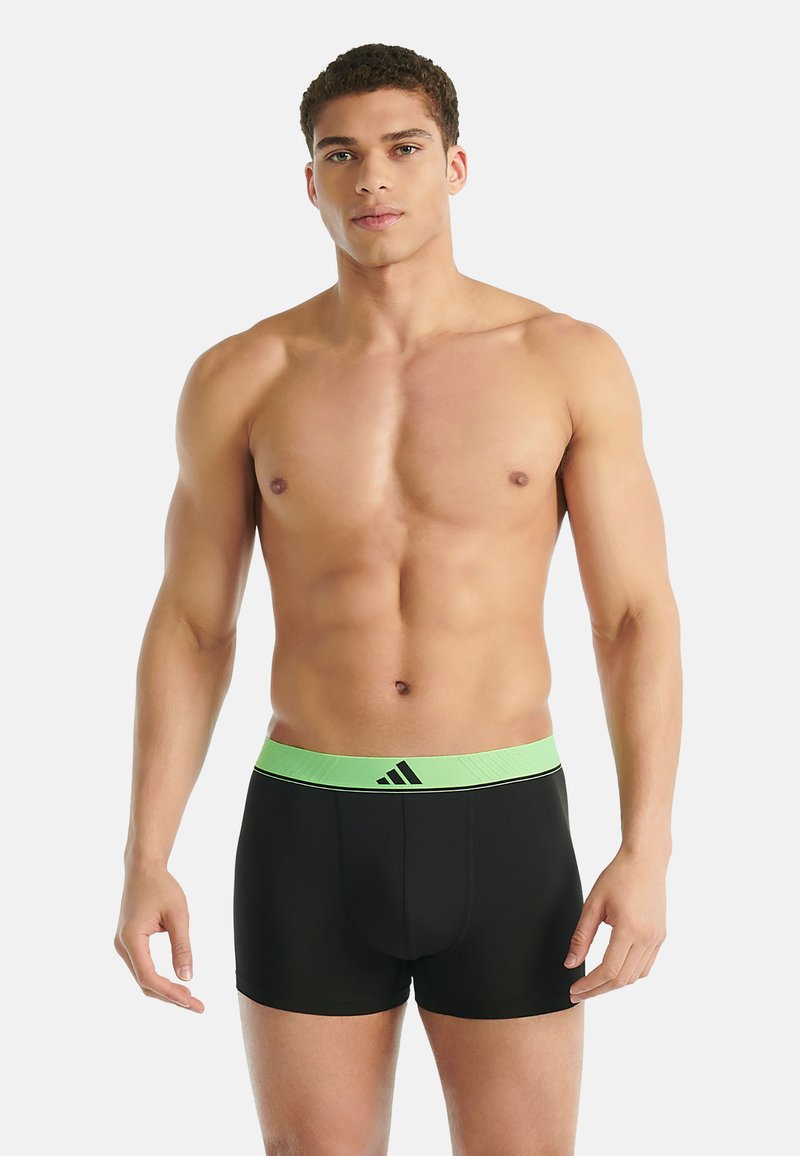 Černé boxerky se širokým zeleným páskem s logem. Materiál je hladký, navržený pro pohodlí a perfektní padnutí.