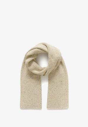 Beige gebreide wollen sjaal met subtiele zwarte vlekjes, in het midden gevouwen en geknoopt op een witte achtergrond.