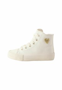 Baskets montantes en toile blanche avec une surface texturée, ornées d'un petit patch en forme de cœur doré et rose, et dotées d'un embout en caoutchouc classique.