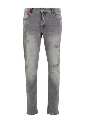 Gai pelēki džinsi no denima ar nodiluma vietām, kuru dizainā ir izsistumi un sarkans logo jostasvietā. Tie ir taisna piegriezuma, klasiskā piecu kabatu stilā.