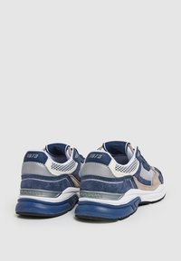 Blå och grå sportskor med mocka och mesh-material, med en dämpad sula och en etikett "Pepe Jeans 1973" på hälen.