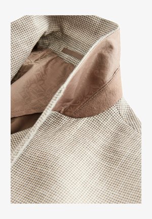 Smeđa i bež tkanina s uzorkom kariranog houndstooth sa mekim smeškim ovratnikom; unutrašnjost ima uzorčanu podstavu; struktura je krojena i prilagođena.