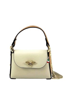 Sac à main en cuir crème avec une forme structurée, un emblème d'abeille doré sur le rabat, des bords noirs et une bandoulière en chaîne amovible.