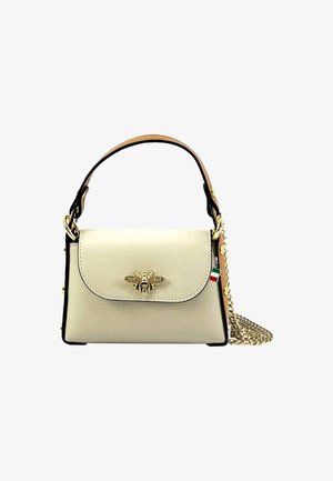 Sac à main en cuir crème avec une forme structurée, un emblème d'abeille doré sur le rabat, des bords noirs et une bandoulière en chaîne amovible.