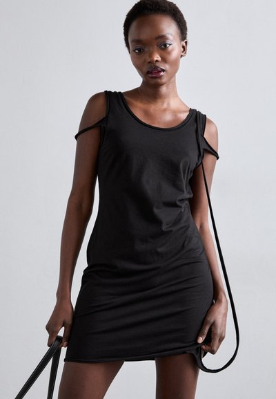 Fekete pamutruha, kerek nyakkivágással, kivágott vállrésszel és testhezálló fazonnal. Simító textúrájú, térd felett végződik.