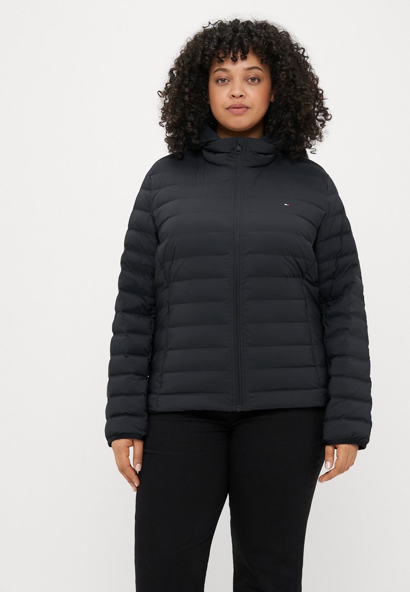 Schwarze Steppjacke mit durchgehendem Reißverschluss, hohem Kragen und horizontal gesteppten Paneelen. Verfügt über Logostickerei auf der Brust und elastische Bündchen.