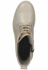 Stivale alla caviglia in pelle beige con punta tonda, collo imbottito e design con lacci. Fodera interna morbida e suola nera per aderenza.