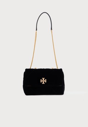 Black velvet handbag with a quilted design, gold hardware, chain and leather strap, featuring a prominent logo on the front.