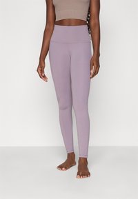 Light purple high-waisted leggings made from stretchy fabric, featuring a smooth texture and seamless design. No visible patterns or logos.