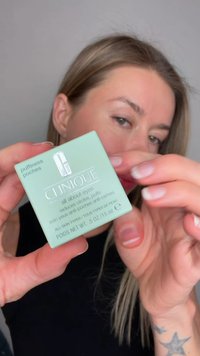 Clinique "All About Eyes" crème in een lichtgroen vierkant potje, gelabeld voor het verminderen van wallen, met een duidelijk logo en een inhoud van 15 ml.