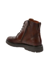 Stivaletti in pelle marrone con dettagli brogue, cerniera laterale e suola in gomma. Presentano una finitura testurizzata e dettagli cuciti.