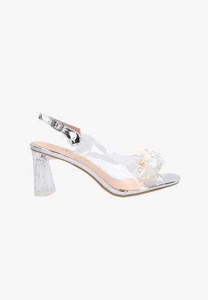 Durchsichtige Slingback-High Heels aus Plastik mit einem blockartigen transparenten Absatz, silbernen Akzenten und einer floralen Verzierung mit Perlendetails an der Zehenpartie.