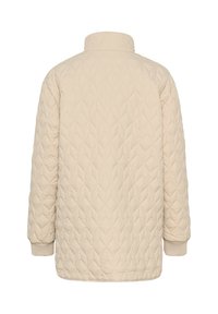 Veste matelassée beige avec un col haut, des manches longues et des poignets côtelés. Présente un motif en losange sur une surface en tissu lisse.