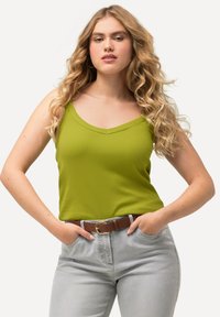 Limetkově zelený žebrovaný top bez rukávů s V- výstřihem a širokými ramínky. V kombinaci se světle šedými džíny a hnědým páskem s kulatou sponou.