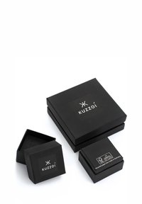 Sorte papir smykkebokse i forskellige størrelser med et logo på toppen og et label for genbrugsmaterialer på den mindste boks. Minimalistisk design.