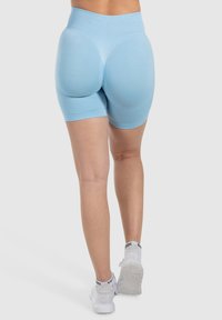 Shorts sportivi azzurri chiari a vita alta con una texture liscia e design sagomato, caratterizzati da una vestibilità aderente e cuciture decorative.