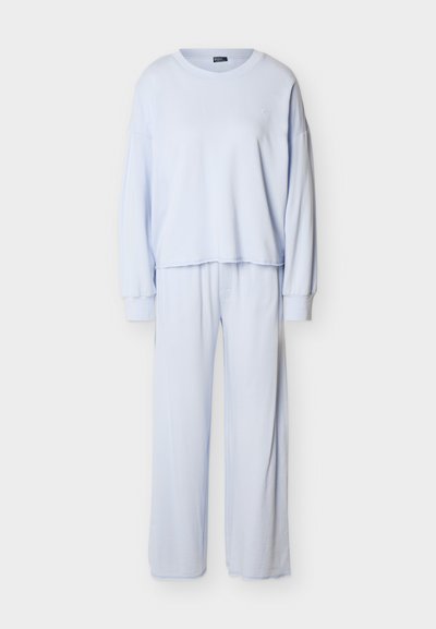 Ανοιχτό γαλάζιο μπλουζάκι με μακριά μανίκια και στρογγυλή λαιμόκοψη, συνδυασμένο με παντελόνι φαρδιάς γραμμής, από απαλό ύφασμα, σετ άνετης ένδυσης για χαλάρωση.