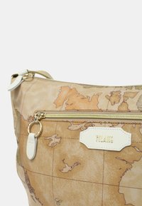 Borsa a tracolla con motivo mappa in beige, dotata di una cerniera e dettagli crema. Include una tasca frontale con cerniera dorata e un'etichetta del marchio.