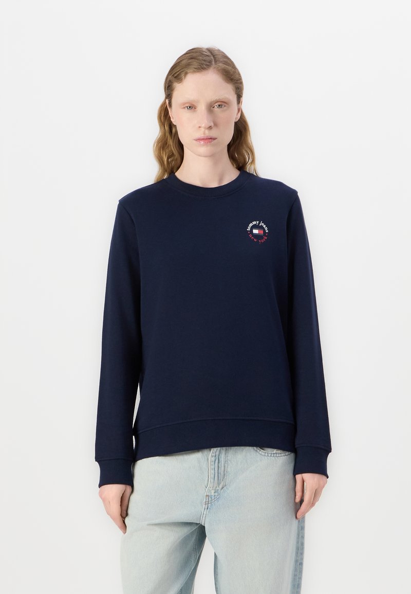 Sudadera azul marino hecha de una mezcla de algodón, cuenta con un escote redondo, mangas largas y un pequeño gráfico de logo en el pecho.