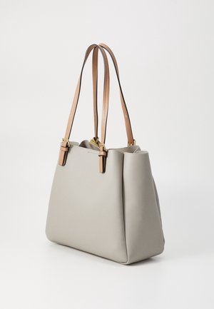 Jasnoszara skórzana torba typu tote z podwójnymi, jasnobrązowymi skórzanymi paskami na ramię i detalami w postaci złotych sprzączek, stojąca na białym tle.