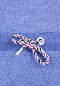 Modrá sweats tkanina s texturovaným povrchem, s růžovým, bílým a černým proužkovaným šňůrkem pro stažení, procházejícím kovovým okem v pase.