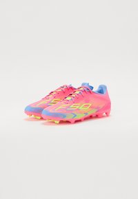 Incaltaminte cu un bleu vibrant, cu accente albastre, un design texturat si o talpa multicolora cu cuie pentru aderenta.