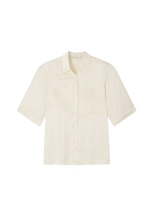 Chemise crème à manches courtes avec boutons et broderie florale subtile, col classique, présentée sur fond blanc.