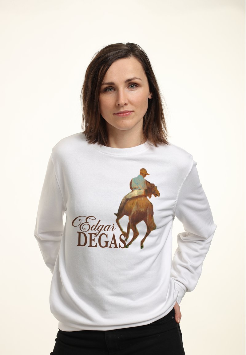 Femme aux cheveux bruns mi-longs portant un sweat-shirt blanc avec un cavalier sur un cheval et le texte "Edgar Degas".
