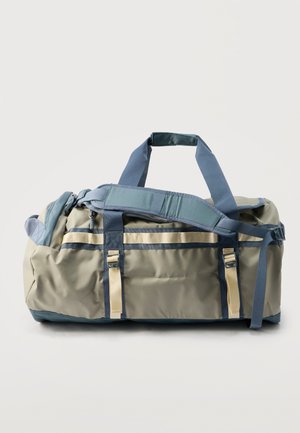 Rechteckige khakifarbene und blaue Reisetasche mit zwei Tragegriffen, gepolstertem Schultergurt, vorderen Schnallenriemen und Hauptfach mit Reißverschluss.