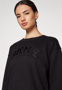 DKNY VARSITY APPLIQUE LOGO LONG LINE CREW NECK PULLOVER - Sweatshirt - black