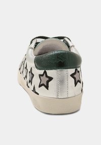 Stříbrné tenisky s černými a šedými hvězdicovými vzory. Zelené akcenty kolem paty a na jazyku. Gumová podešev. Hladký, lesklý povrch.