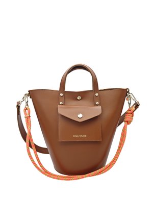 Sac à main trapèze en cuir marron avec poche avant et bouton argenté, double anses et bandoulière détachable en corde rayée orange.