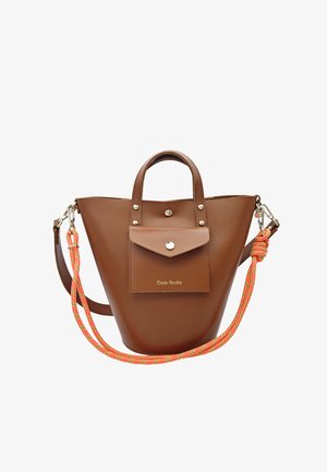Sac à main trapèze en cuir marron avec poche avant et bouton argenté, double anses et bandoulière détachable en corde rayée orange.