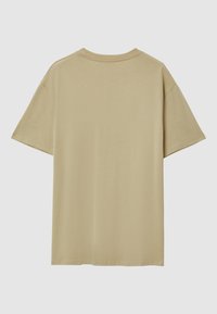 Maglietta corta beige in tinta unita vista da dietro con collo rotondo su uno sfondo grigio.