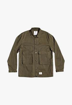 Veste boutonnée vert olive avec deux grandes poches à rabat à l’avant, un col, des manches longues avec des poignets en velcro, et une petite étiquette blanche près de l’ourlet.