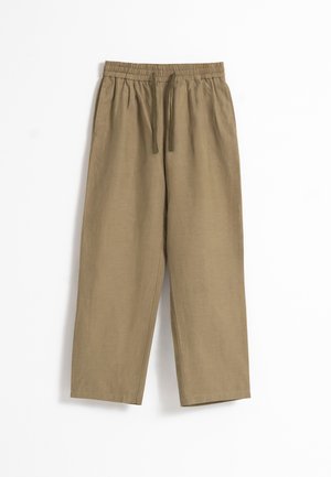 Pantalones holgados de color marrón claro con cintura elástica y cordón, piernas rectas y bolsillos laterales, extendidos sobre fondo blanco.