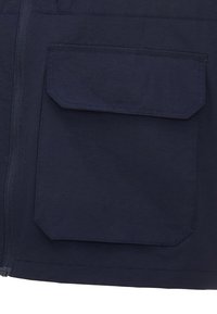 Mörkblå jacka med blixtlås, med en stor fyrkantig ficka på sidan, tillverkad av ett slätt, hållbart tyg.