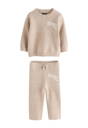 Béžová pletená súprava sveter a nohavice pre deti, oboje s nápisom "NYC", obsahujúca sveter s okrúhlym výstrihom a nohavice so šnúrkou.