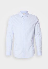 Camisa azul claro de botones con finas rayas verticales, mangas largas y cuello clásico. Cuenta con un pequeño logo en el pecho.