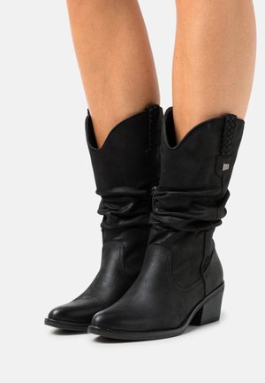 Stivale da cowboy in finta pelle nera con un design arricciato, dettagli intrecciati nella parte superiore e un tacco modesto, che presenta una punta affusolata ed elegante.