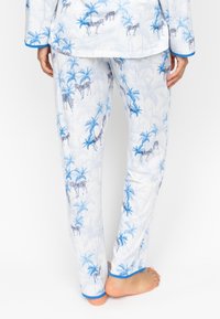 Witte pyjama-set met blauwe zebra- en palmboompatronen. Met blauwe bies op de manchetten en de zoom. Zachte stof; relaxte pasvorm.