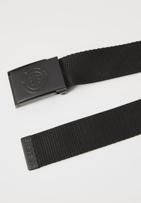 Black nylon belt with a rectangular metal buckle featuring an embossed logo, and a woven texture throughout the belt.